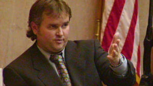 A man motions with his hand in court