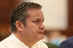 A profile view of a man sitting in court