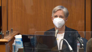 A person in a face mask testifies in court