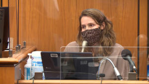 A woman appears in court wearing a mask