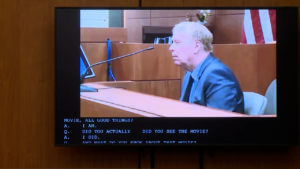 a man appears in videotaped testimony