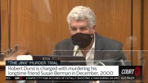 A man testifies in court wearing a mask