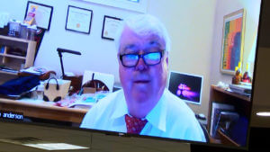 A man is seen on a computer screen