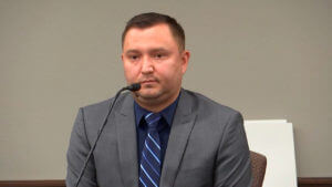 man in suit and tie testifies