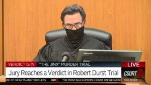 A judge wearing a mask sits in court