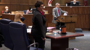 Janet Hinds pulls her mask down and speaks during her trial