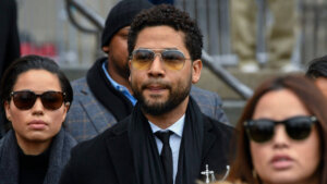 Jussie Smollett wears glasses and a jacket
