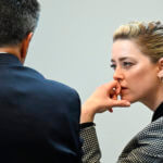 Actor Amber Heard speaks with a legal team