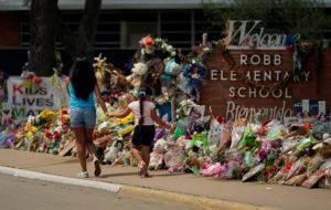 Visitors walk past a makeshift memorial