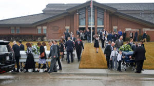 caskets are carried out of a building