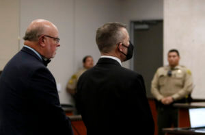 Paul Flores stands with his attorney in court.