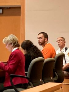 Adam Montgomery, with defense attorneys Caroline Smith, far left, and Paige Pihl-Buckley listens during a hearing