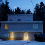 police officer stands guard in his vehicle at the home where four University of Idaho students were found dead