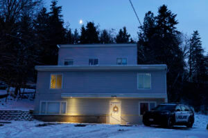 police officer stands guard in his vehicle at the home where four University of Idaho students were found dead