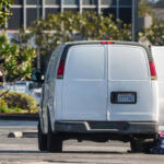 A forensic photographer takes pictures of a van's window and its contents in Torrance, Calif., Sunday, Jan. 22