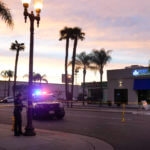 A police officer ties tape around a light pole in Monterey Park, Calif., Sunday, Jan. 22, 2023