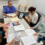 Hawaii Innocence Project co-director Kenneth Lawson, background center, and law students go over files and photos related to the 1991 murder of Dana Ireland in Honolulu