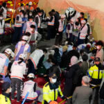 Rescue workers treat injured people on the street near the scene of a crowd surge in Seoul