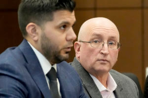 Robert E. Crimo Jr., right, father of Robert Crimo III, listens to his attorney George Gomez during an appearance before Judge George D. Strickland