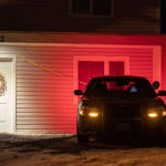 A private security officer sits in a vehicle, Tuesday, Jan. 3, 2023, in front of the house in Moscow, Idaho where four University of Idaho students were killed