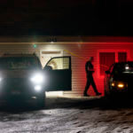 A private security officer sits in a vehicle, Tuesday, Jan. 3, 2023, in front of the house in Moscow, Idaho where four University of Idaho students were killed