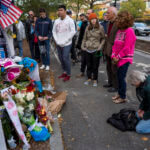 A group pauses, with some in prayer, at a makeshift memorial on a New York City bike path, on Nov. 4, 2017