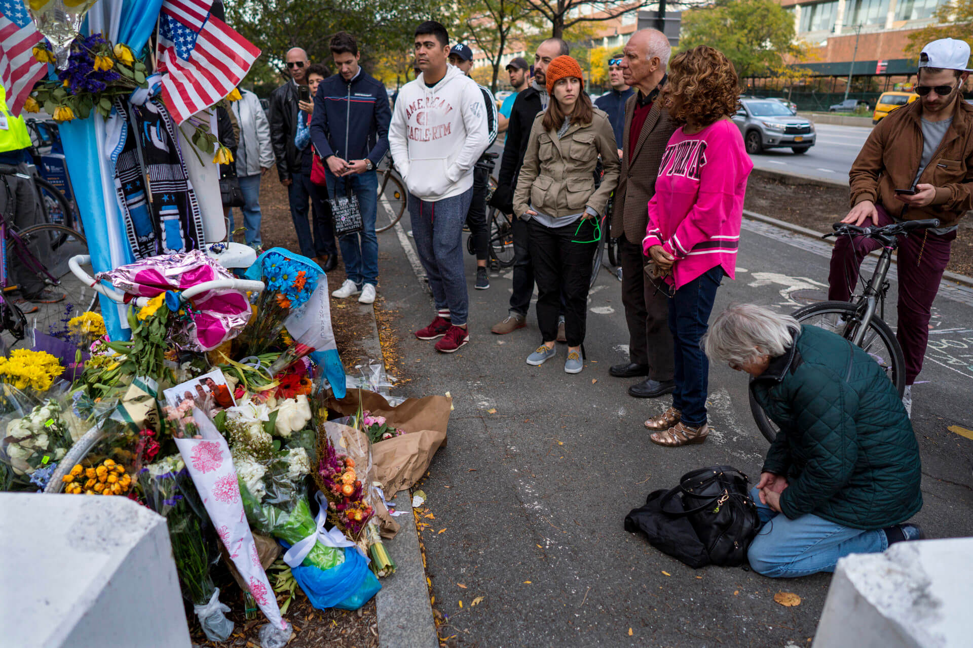 A group pauses, with some in prayer, at a makeshift memorial on a New York City bike path, on Nov. 4, 2017
