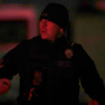 A law enforcement officer stands stands near the Enoch, Utah, home where eight family members were found dead