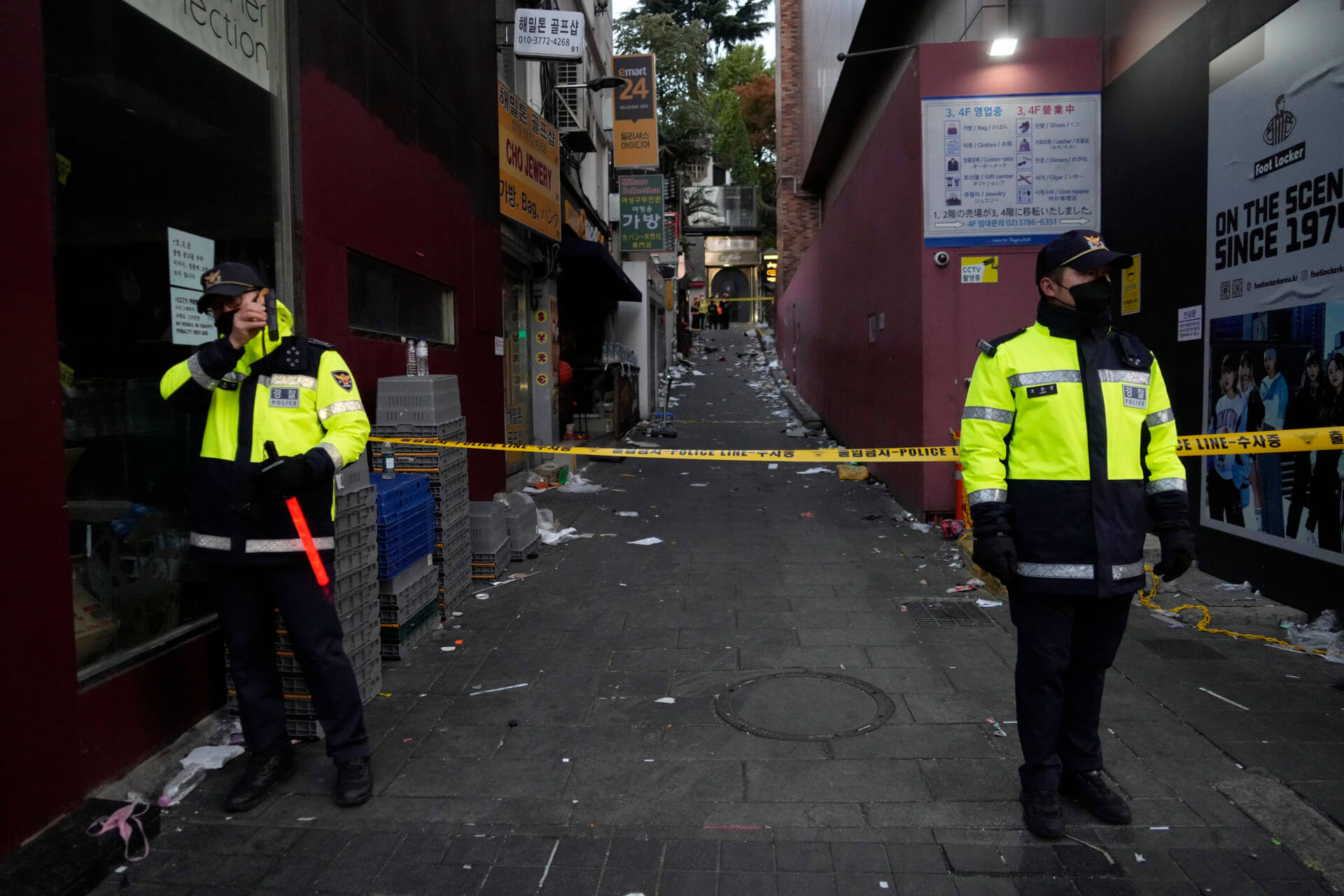 Police officers stand guard at the scene where dozens of people died and were injured during a crowd surge in Seoul