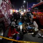 Rescue workers treat injured people on the street near the scene of a crowd surge in Seoul