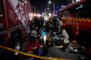 Rescue workers treat injured people on the street near the scene of a crowd surge in Seoul