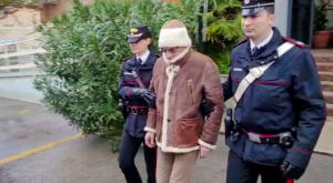 Matteo Messina Denaro, center, leaves an Italian Carabinieri barrack soon after his arrest at a private clinic in Palermo