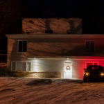 A private security officer sits in a vehicle on Jan. 3, 2023, in front of the house in Moscow