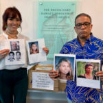 Hawaii Innocence Project co-director Kenneth Lawson, background center, and law students go over files and photos related to the 1991 murder of Dana Ireland in Honolulu