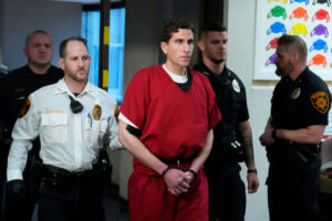 Brian Kohberger, flanked by officers, walks through the courthouse.