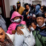 Latryna Sims, partner of Calvin Munerlyn, center, cries on the shoulder of his uncle