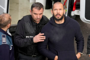 Police officers escort Andrew Tate, left, handcuffed to his brother Tristan Tate to the Court of Appeal in Bucharest, Romania, Wednesday, Feb. 1,