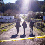 FBI officials walk towards the crime scene at Mountain Mushroom Farm