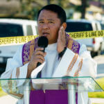 Rev. Albert Avenido holds his hands on his cheek, as he quotes the Bible verse Matthew 5:38–39