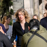 Elizabeth Holmes, middle, walks to federal court