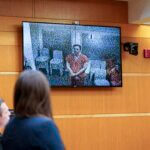 Suspect appears on a screen in courtroom