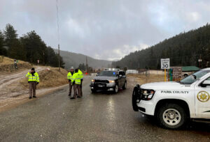Sheriff deputies block a road in the town of Bailey, Colo