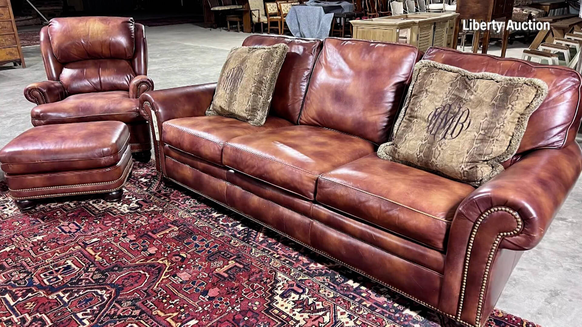 Brown leather sofa with striped throw pillows, matching arm chair and ottoman