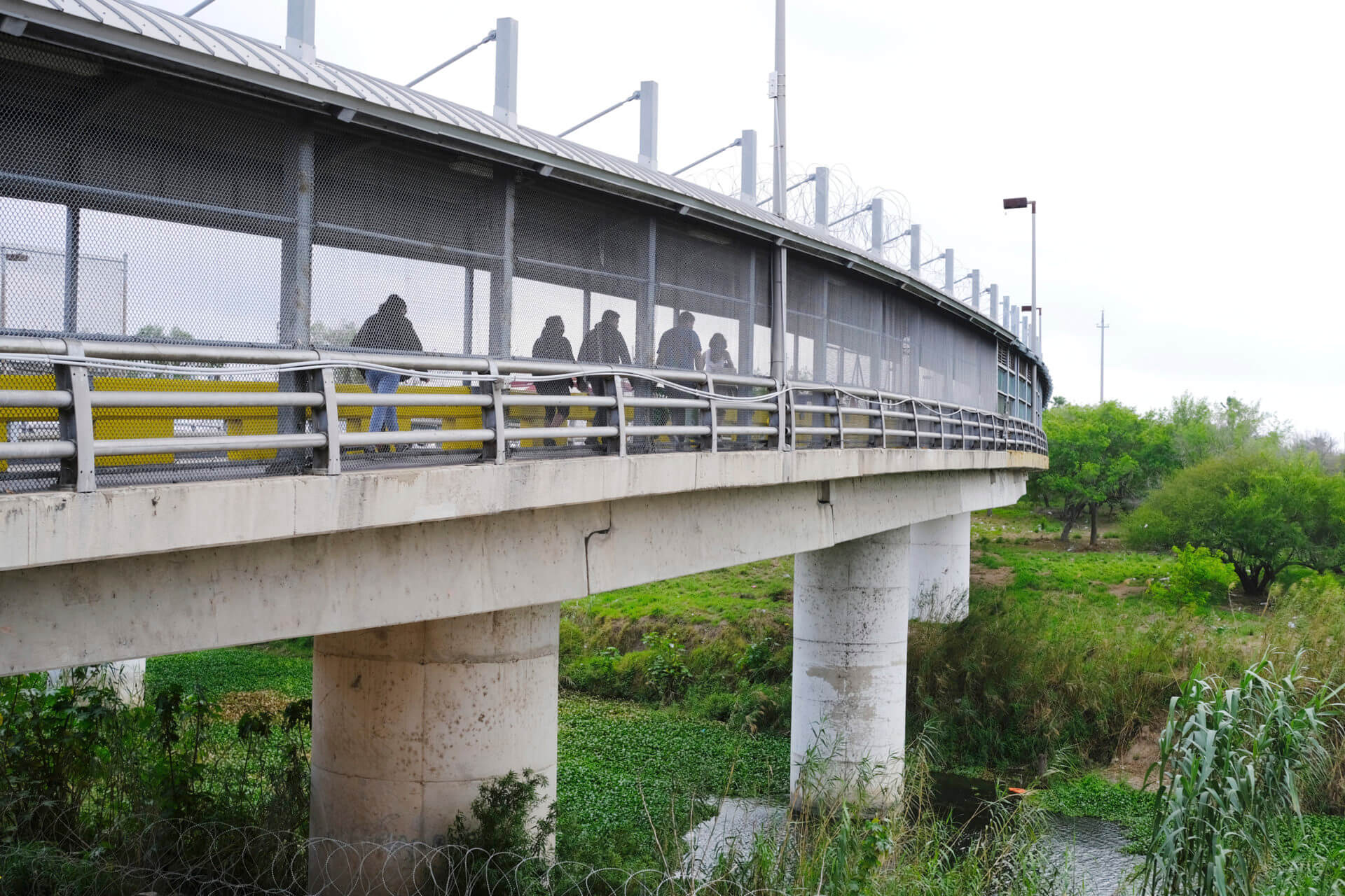 Pedestrians cross Gateway International Bridge