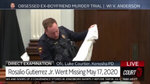 Evidence technician holds a shirt while testifying