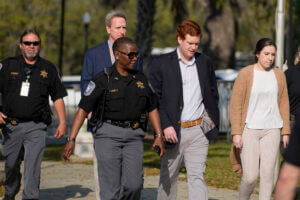 Buster Murdaugh and Brooklyn White walk with three police officers.