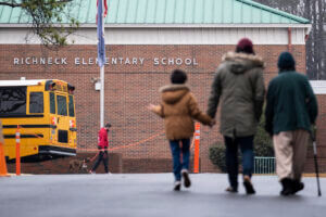 students and parents walking away from the camera into Richneck Elementary School