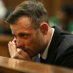 Oscar Pistorius speaks on a mobile phone in the High Court in Pretoria