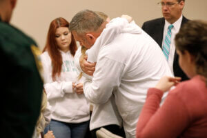 Forrest Bailey, the father of victim Tristyn Bailey, gets a hug from a family member