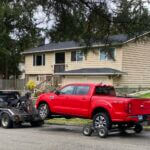 A red truck with Oregon license plates is towed from the scene in Redmond, Wash